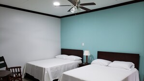 A hotel room with two single beds, a desk, a chair, a nightstand with a lamp, and a ceiling fan. - Vivens Bed & Breakfast Sarchi (Sarchí Sur)