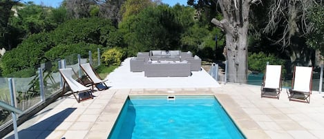 Una piscina al aire libre, tumbonas