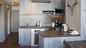 Cocina moderna con isla integrada, electrodomésticos de acero inoxidable y un adhesivo de ciervo en la pared.
