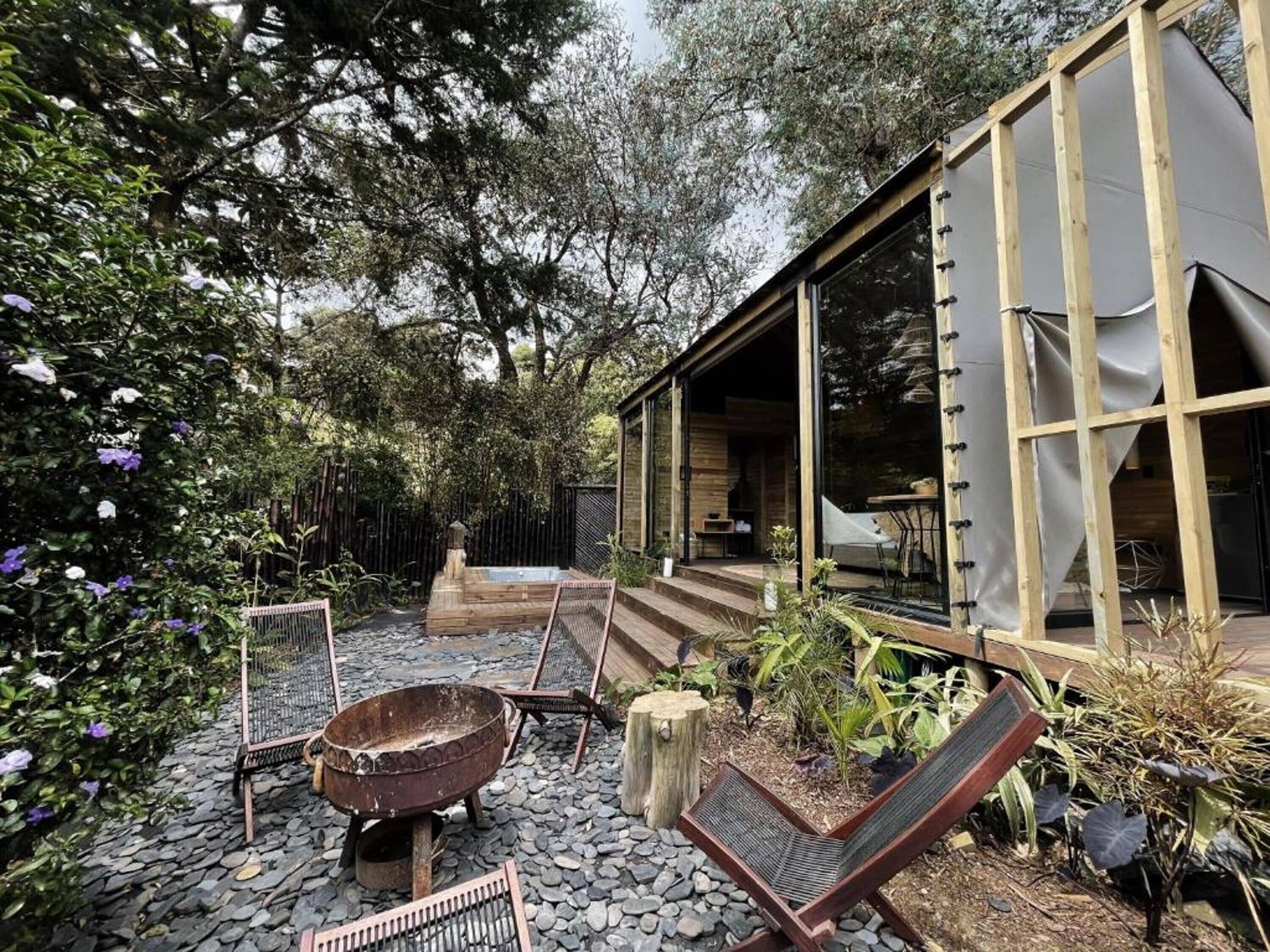 A rustic outdoor seating area with a fire pit, lounge chairs, and a wooden deck.