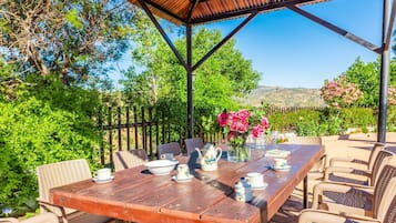 Enjoy al fresco dining under a shaded pergola with a beautifully set table for four.