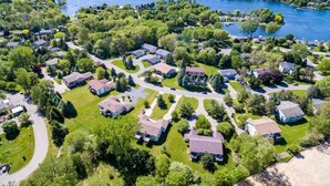 Vue aérienne d’un quartier résidentiel avec des maisons, des routes et un lac.