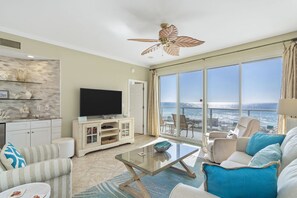 Relax in this stylish living room with a large flat-screen TV, comfortable sofa, and ocean views.