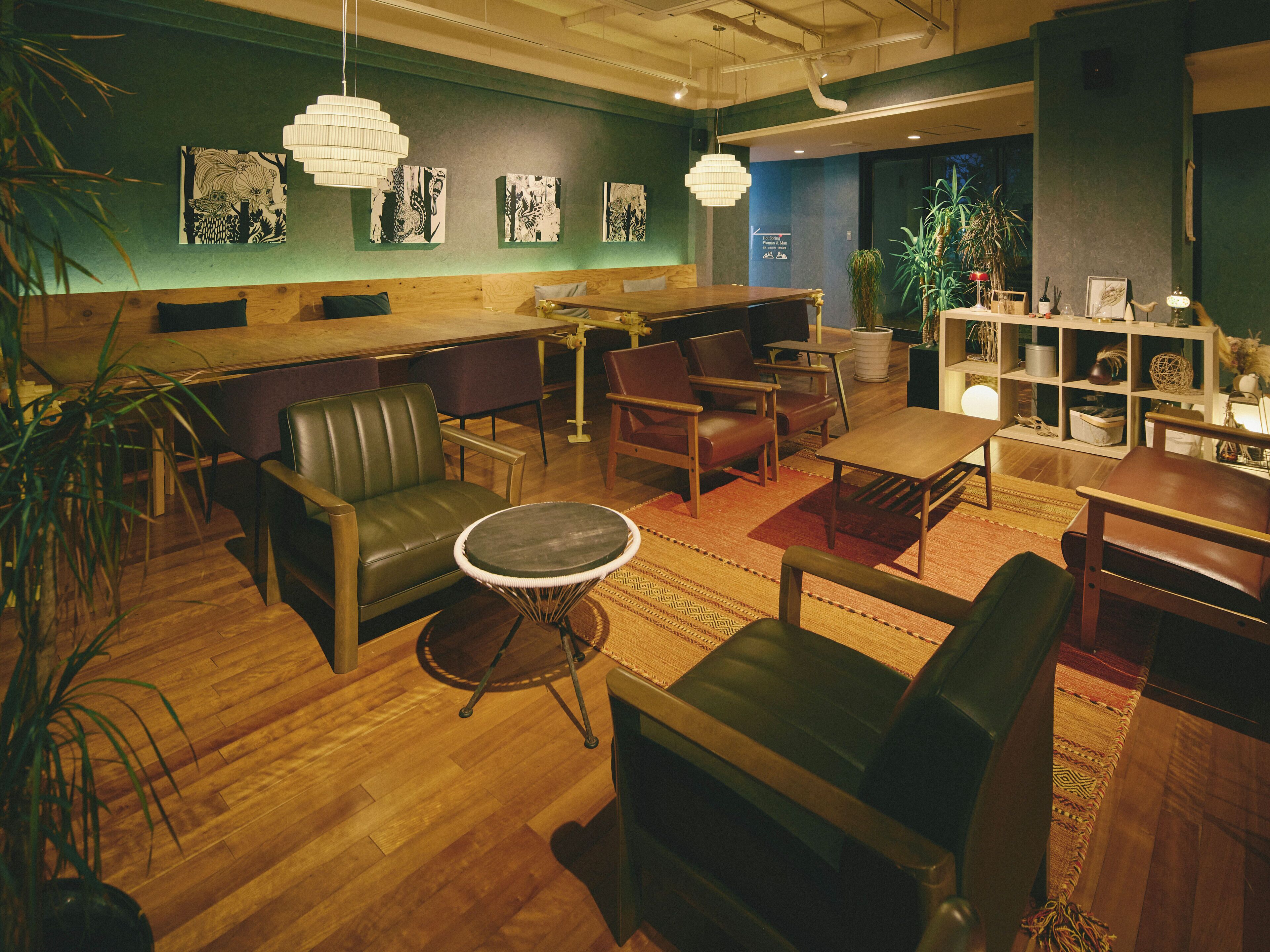 A modern lounge area with leather seating, a round table, and artwork on the walls.
