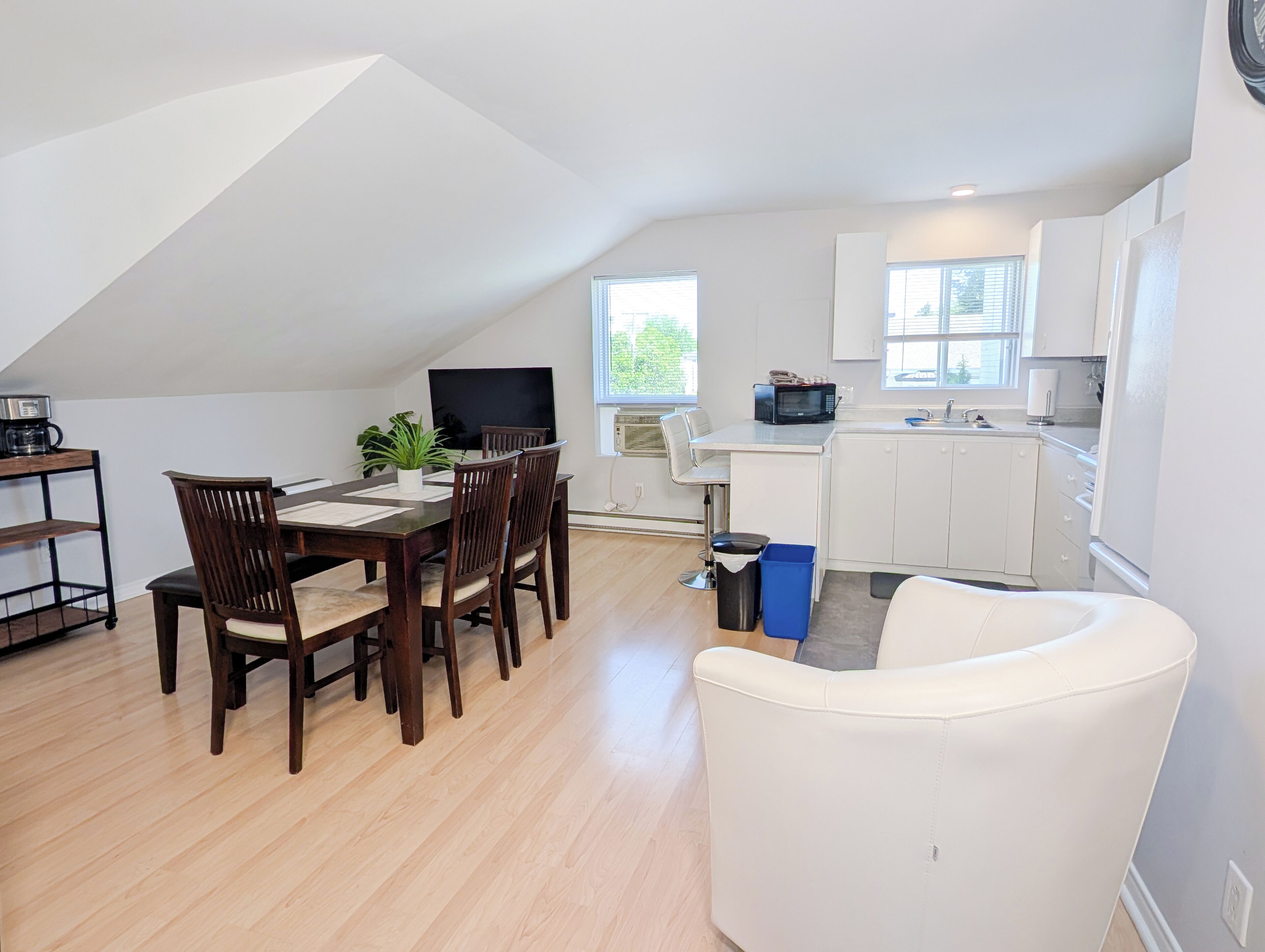 A modern apartment with a dining area, kitchen, and living space.