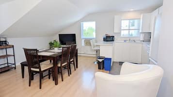 A modern apartment with a dining area, kitchen, and living space.