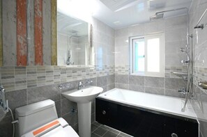 A modern bathroom with a toilet, sink, and bathtub.