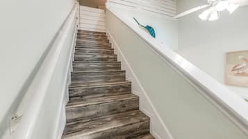 Una escalera con escalones de madera y barandillas blancas.