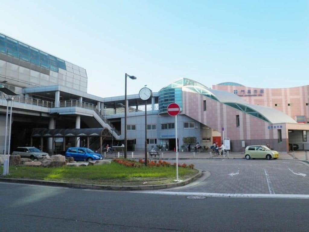 Un edificio moderno con fachada de vidrio, un cartel de prohibido el paso y un paso de peatones.