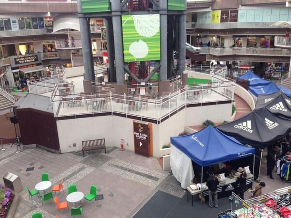Un centro comercial interior con varios niveles, un atrio central y zonas de estar al aire libre.