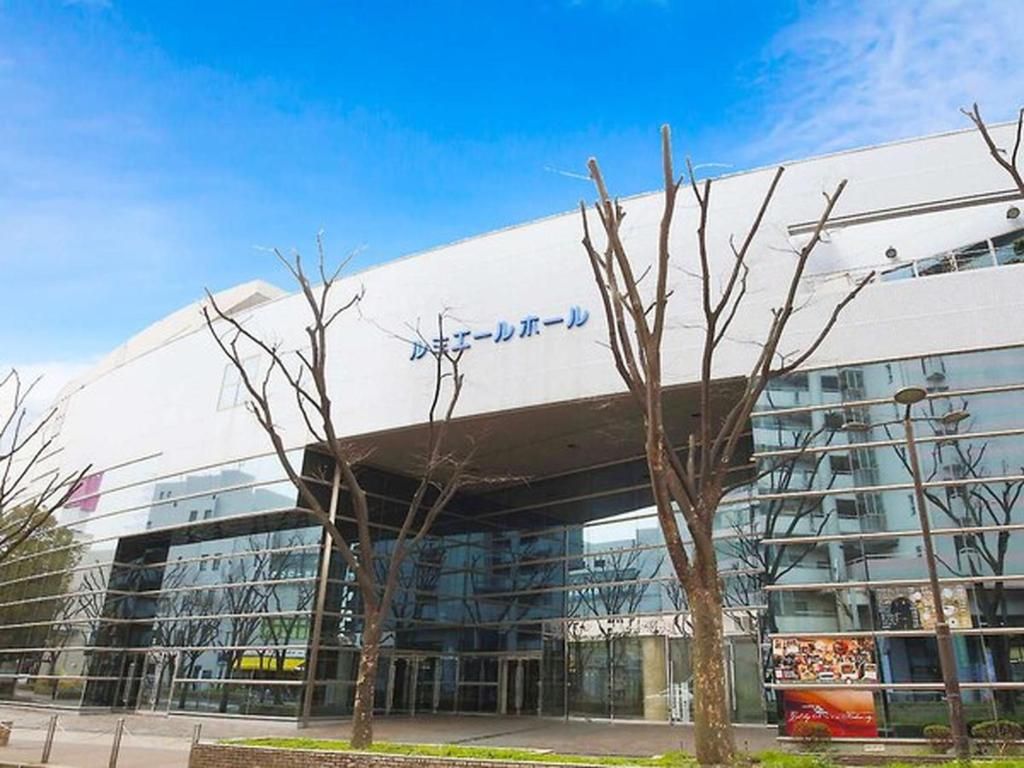 A modern building with a glass facade and a sign in a foreign language.