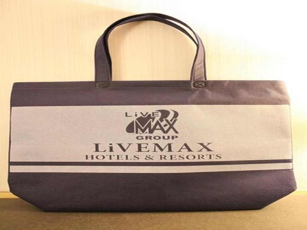 A tote bag with the LiveMAX Group logo and the name 'LiVEMAX HOTELS & RESORTS' printed on it.