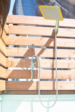 A wooden deck with a showerhead and hose. - Ini Kobe Hostel & Cafe Bar (Kobe)