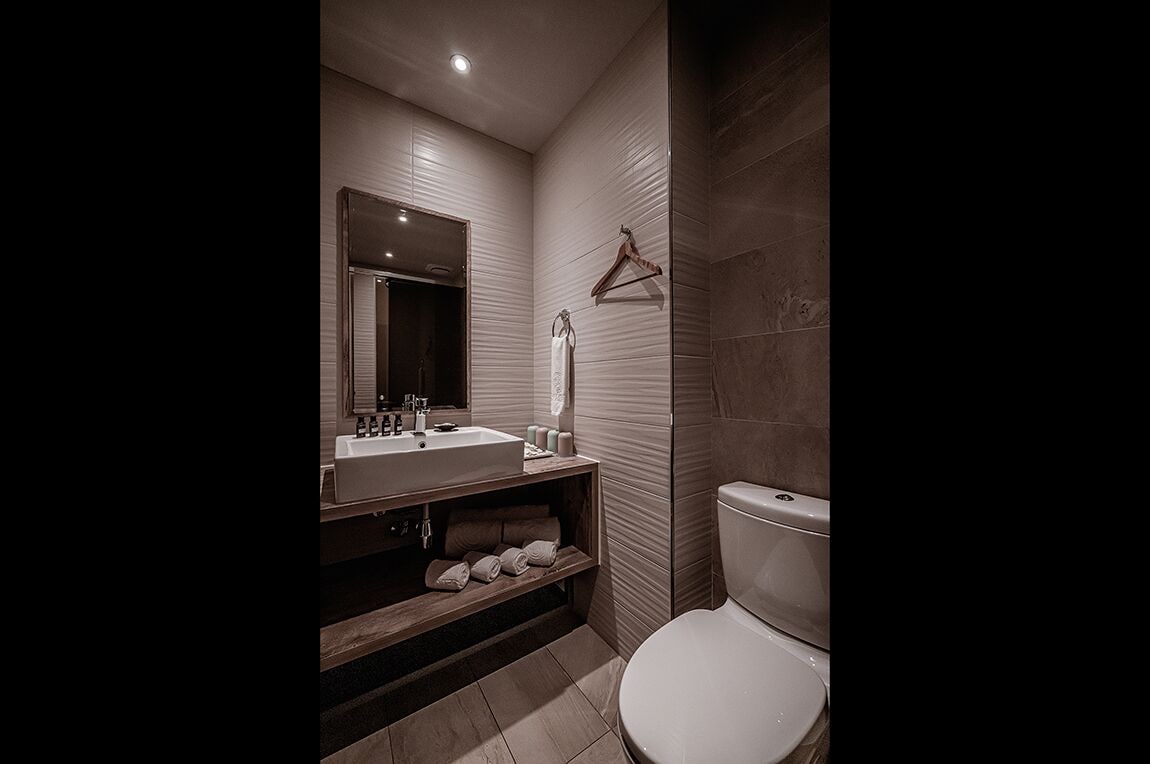 Une salle de bain moderne avec un lavabo, un miroir et des toilettes.