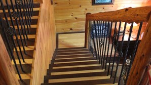 A wooden staircase with black railings leading to a lower level. - Secluded Cabin Outside of Nashville - The Lodge at Oak Haven Farm (White Bluff)