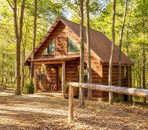 A wooden cabin with a porch, large windows, and a sign that reads 'Welcome.' - The Lodge at Oak Haven Farms - Cabin Outside of Nashville (White Bluff)