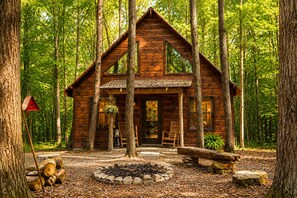 A wooden cabin with a porch, surrounded by trees. - Secluded Cabin Outside of Nashville - The Lodge at Oak Haven Farm (White Bluff)