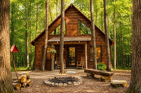 A wooden cabin with a porch, surrounded by trees.. The Lodge at Oak Haven Farms - Cabin Outside of Nashville