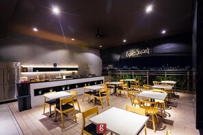 A rooftop restaurant with a city view, featuring a bar area, multiple tables, and chairs. - Expressionz Suites KLCC by Like Home (Kuala Lumpur)
