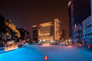 A cityscape at night with illuminated buildings, a fountain, and a pool. - Expressionz Suites KLCC by Like Home (Kuala Lumpur)