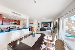 Enjoy meals with friends and family at the large dining table, surrounded by a comfortable seating area and a sleek kitchen.