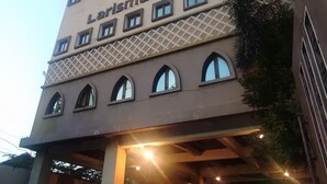 A building with the sign 'Larismanis' on the facade, featuring a series of windows and a covered entrance area. - Hotel Syariah Larismanis (Semarang)