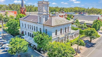 A historic building with a clock tower, surrounded by trees and a street.