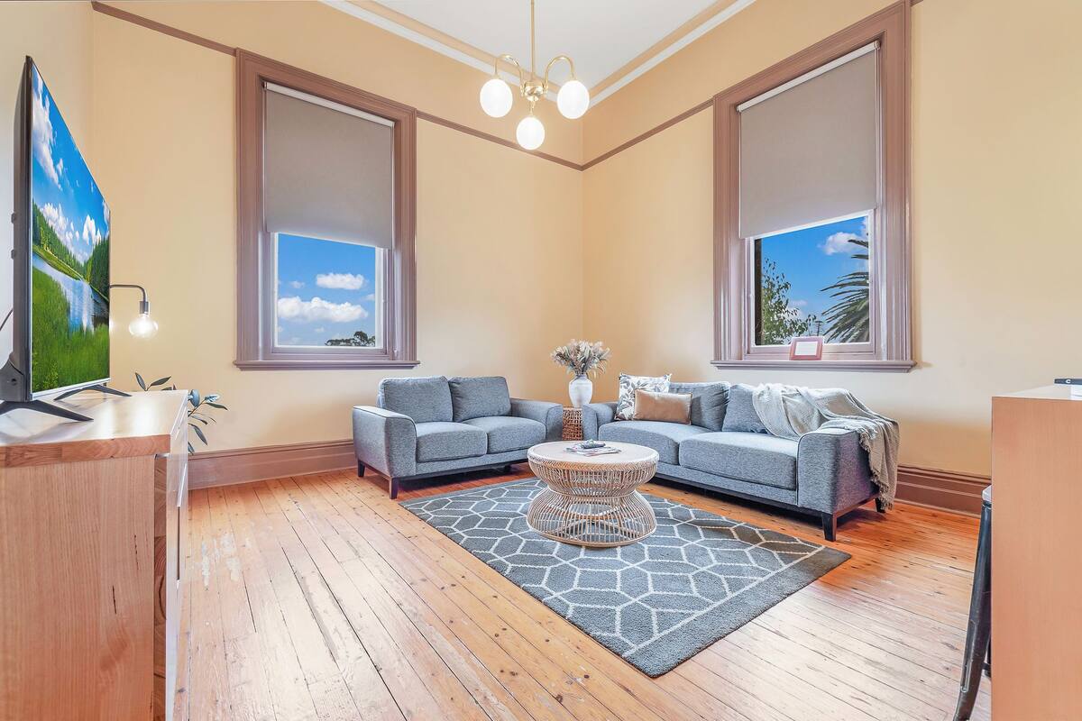 A living room with a grey sofa set, a coffee table, and a TV on a wooden cabinet.