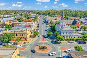 A town square with a roundabout, historic buildings, and a prominent church steeple. - Clocktower Suites (Echuca)