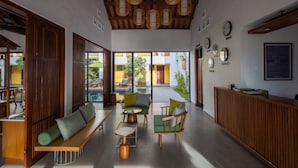 Un intérieur moderne avec des meubles en bois, un comptoir d’accueil et une vue sur l’extérieur.
