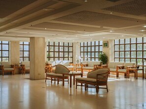 A spacious lobby with large windows, wooden furniture, and a tiled floor. - Kinsa Holiday Hotel (Jinsha)