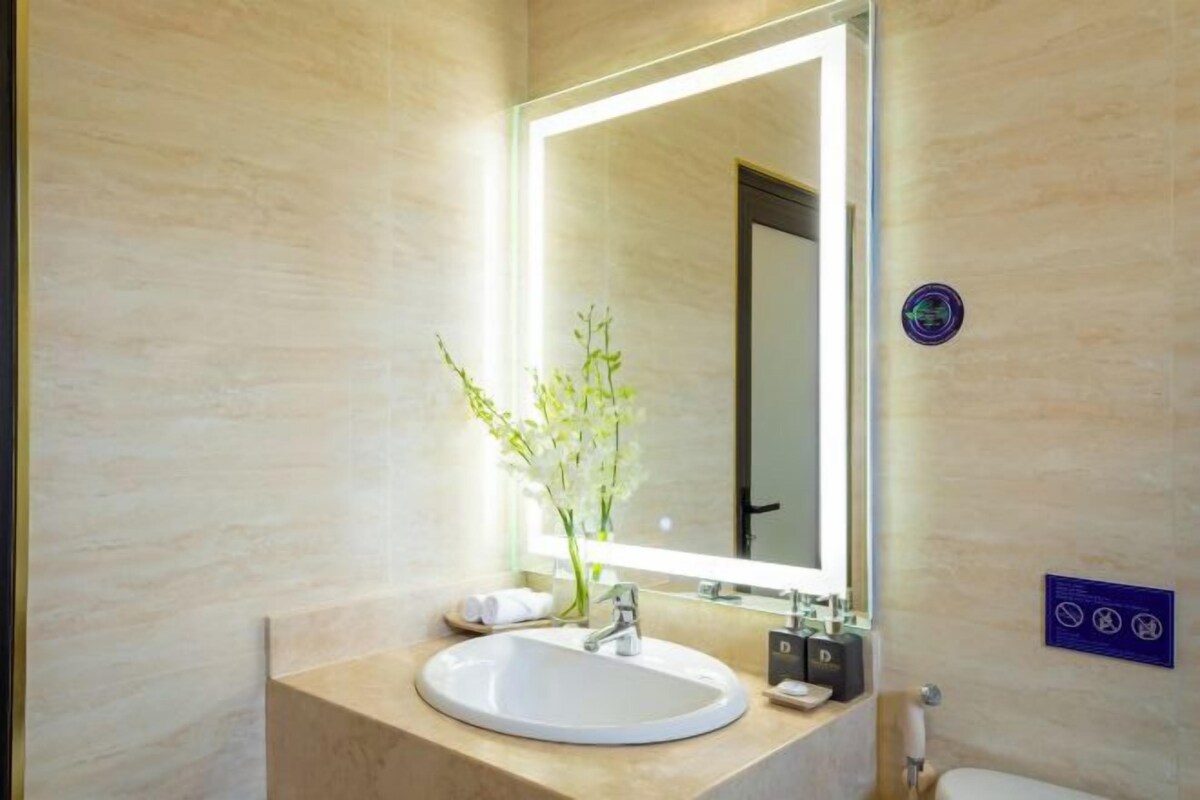 Une salle de bain moderne avec un grand miroir, un lavabo et des toilettes.