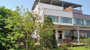 A two-story building with a covered patio area, large windows, and a brick facade. - Pu Su Bed and Breakfast (Lugu)