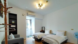 A hotel room with two beds, a grey sofa, a wooden chair, a ceiling fan, and an air conditioning unit. - Pu Su Bed and Breakfast (Lugu)