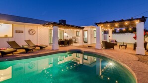 A pool area with lounge chairs, a pergola with string lights, and a dining area with outdoor furniture. - OLD TOWN + HOME + HEATED Private POOL + 4 Bed/ 2.5 Bath + NEW Remodel+ Game Room (Scottsdale)