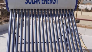 Eine Solaranlage mit einem zylindrischen Tank und mehreren Leitungen.