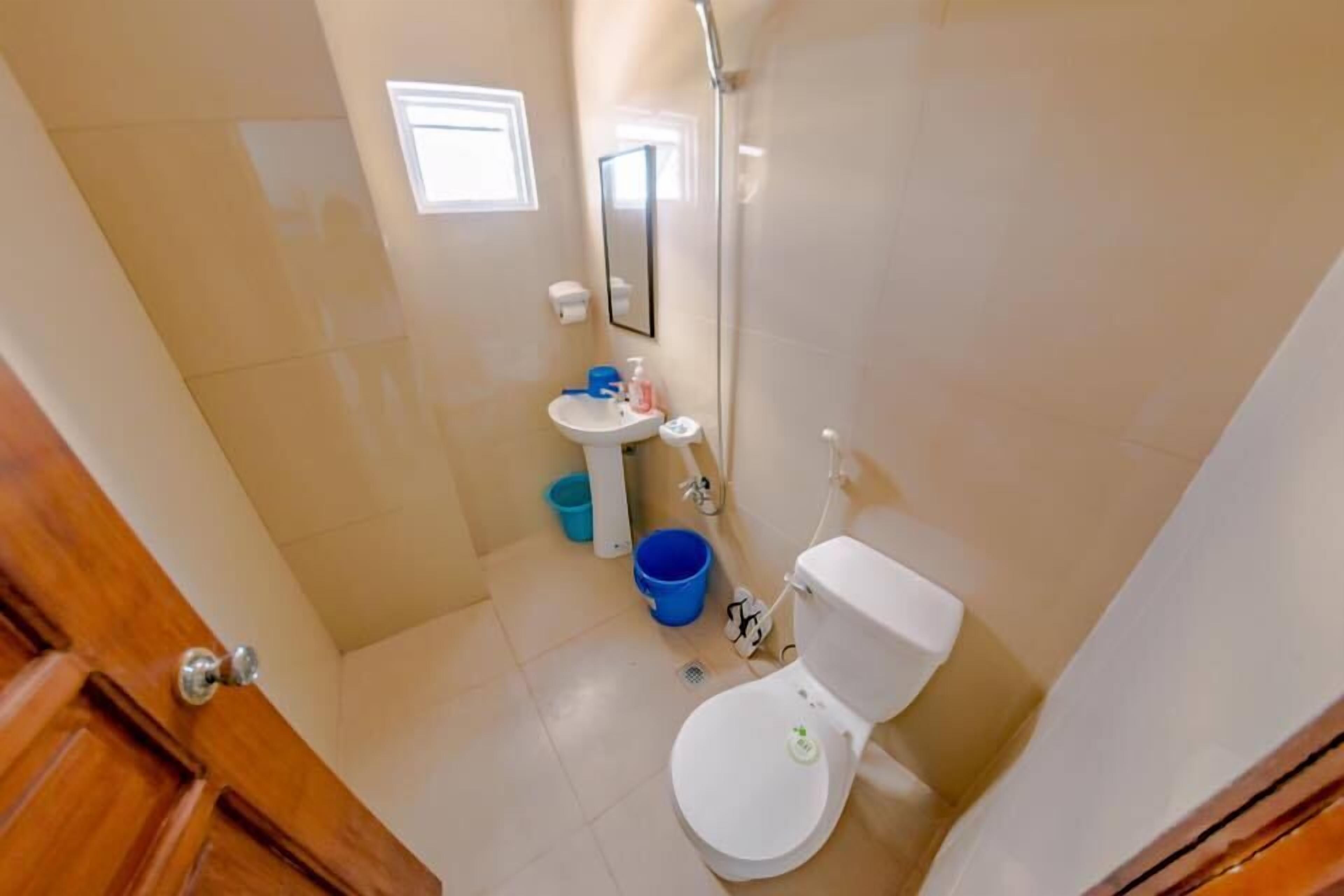 A compact bathroom with a toilet, sink, and shower.