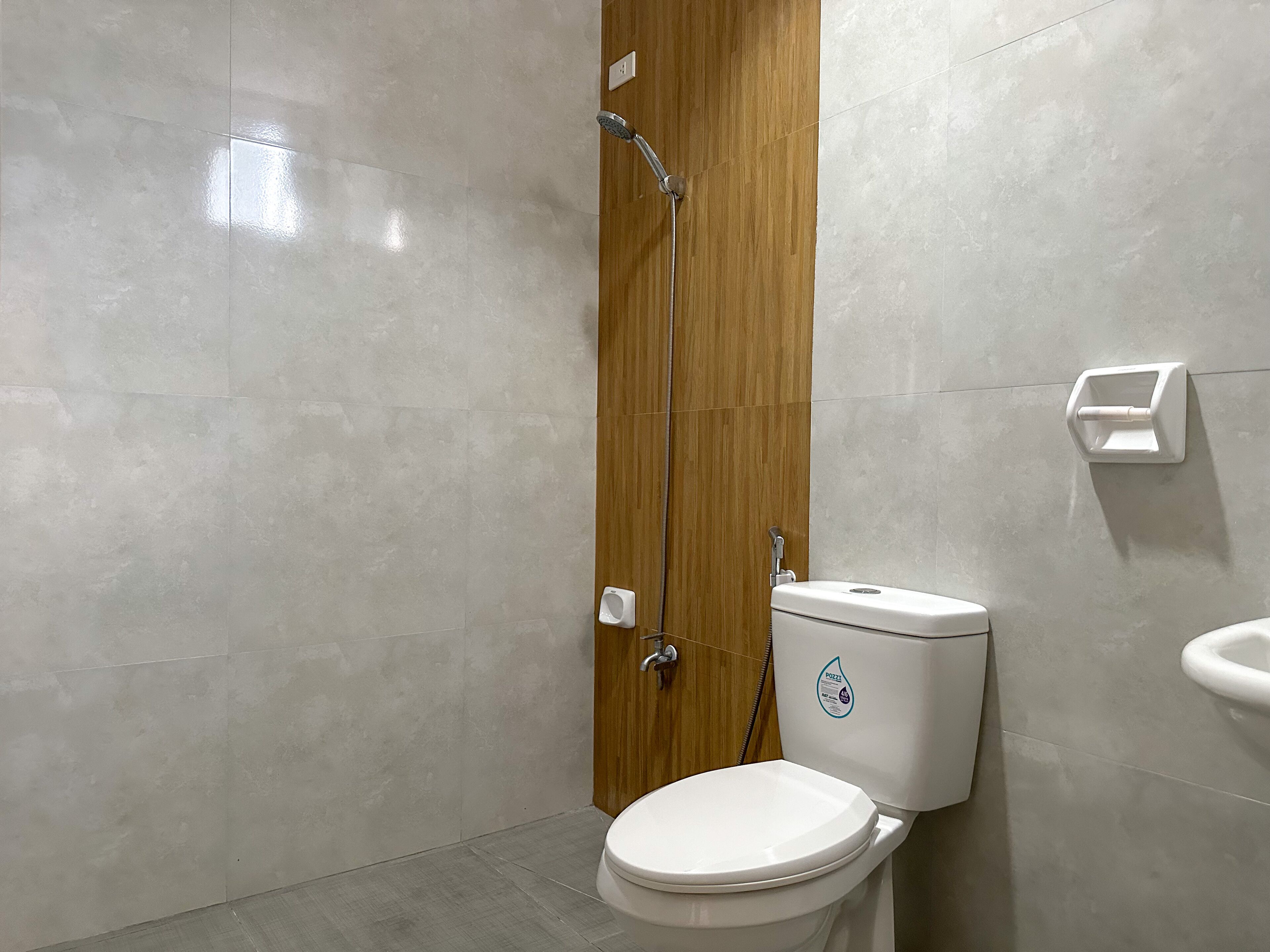 Un baño moderno con inodoro, ducha y secador de manos.