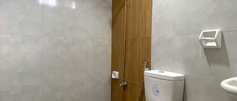Un baño moderno con inodoro, ducha y secador de manos.