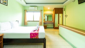 A hotel room with a bed, a window with curtains, a mirror, and a television on the wall. - Khum Suk Resort (Hat Yai)