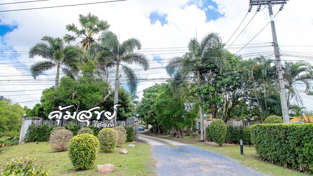 A residential street with palm trees and a clear sky. - Khum Suk Resort (Hat Yai)
