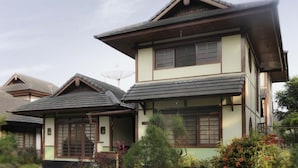 A traditional Japanese house with a two-story structure, wooden beams, and a tiled roof. - VILLA ADE - 0620 KOTA BUNGA PUNCAK (Cipanas)