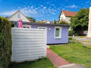 Una propiedad residencial con cerca blanca, un sendero y un pequeño jardín.