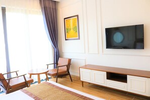 Habitación doble Deluxe | Área de sala de estar | Televisión de pantalla plana de 42 pulgadas con canales por cable 