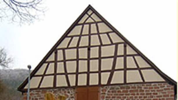 Un edificio con techo triangular y fachada de ladrillo.