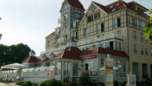 Ein mehrstöckiges Hotel im traditionellen Baustil mit Balkonen und einem zentralen Turm.