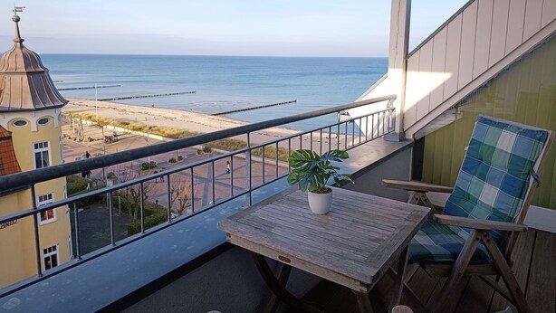 Ein Balkon mit Blick auf Strand und Meer.