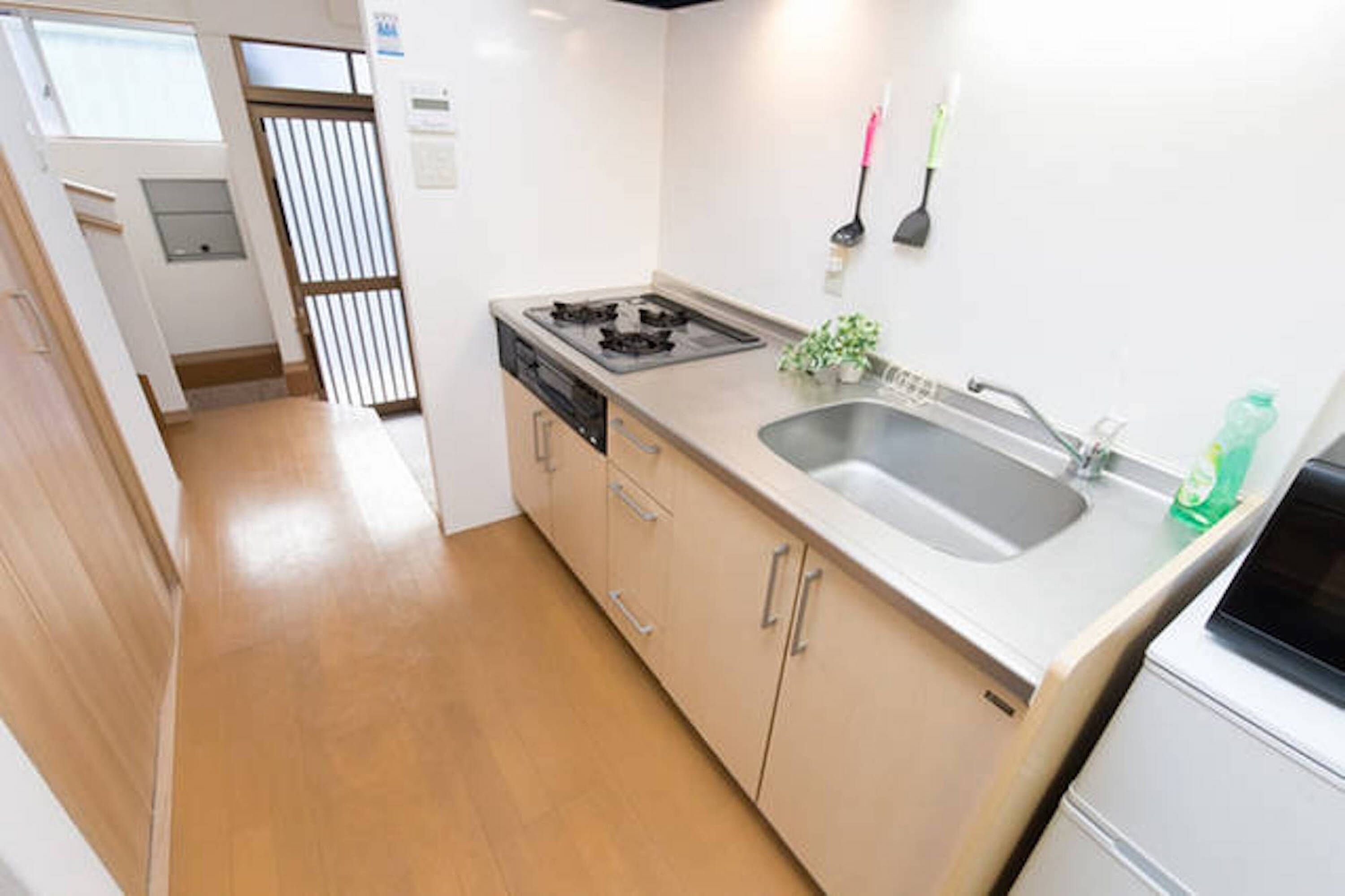 A compact kitchen with a sink, stove, and cabinets.