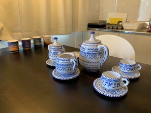 Enjoy a traditional tea service in this elegant setting, complete with teapot, cups, saucers, and sugar bowl.