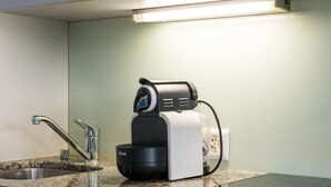 A kitchen with a granite countertop, a built-in stove, a sink, and a coffee maker. - ZH Schmidgasse I - Hitrental Apartment (Zürich)